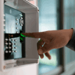 pessoa a registar a assiduidade num relógio de ponto com a impressão digital