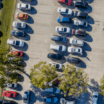 Fotografia de um parque de estacionamento com vários de carros visto de cima